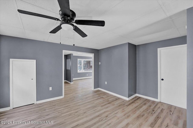 unfurnished room with a paneled ceiling, ceiling fan, and light hardwood / wood-style flooring