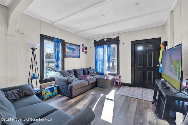 living room featuring beamed ceiling and hardwood / wood-style flooring