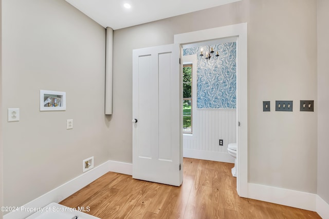 washroom featuring hookup for a washing machine, a chandelier, and hardwood / wood-style flooring