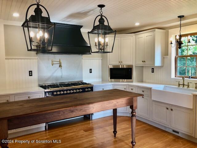 kitchen with white cabinetry, sink, and hanging light fixtures