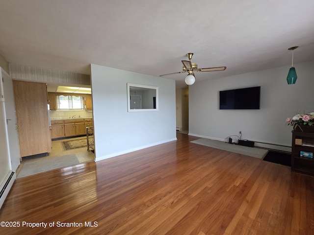 96 W Swallow St, Olyphant, PA 18447 - unfurnished living room featuring light wood-type flooring, ceiling fan, baseboard heating, and a baseboard radiator