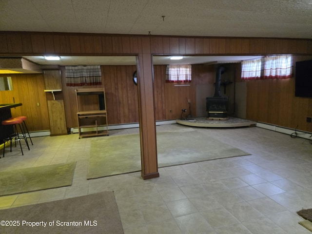 96 W Swallow St, Olyphant, PA 18447 - below grade area with a wood stove, wood walls, and a baseboard heating unit