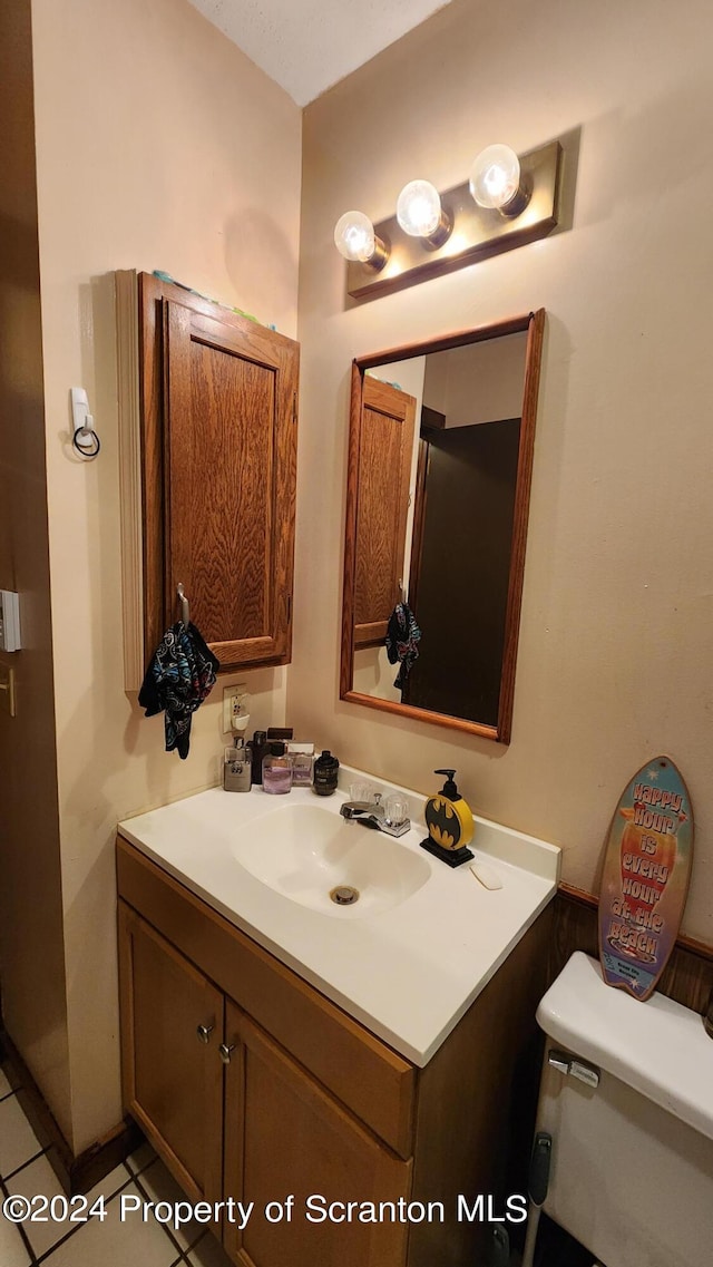 bathroom featuring tile patterned floors, vanity, and toilet