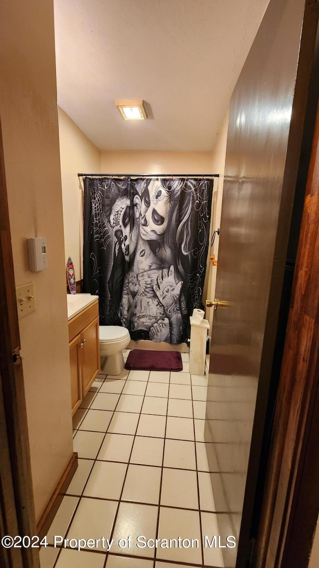 bathroom featuring toilet, vanity, tile patterned floors, and a shower with shower curtain