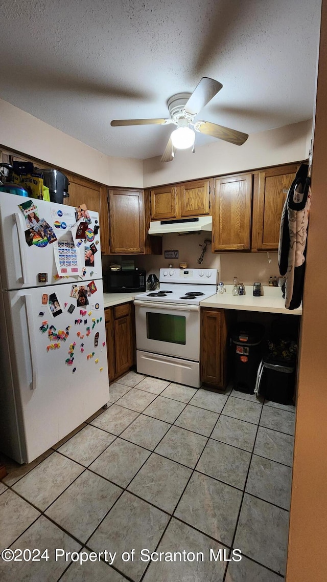 kitchen featuring a textured ceiling, white appliances, light tile patterned floors, and ceiling fan