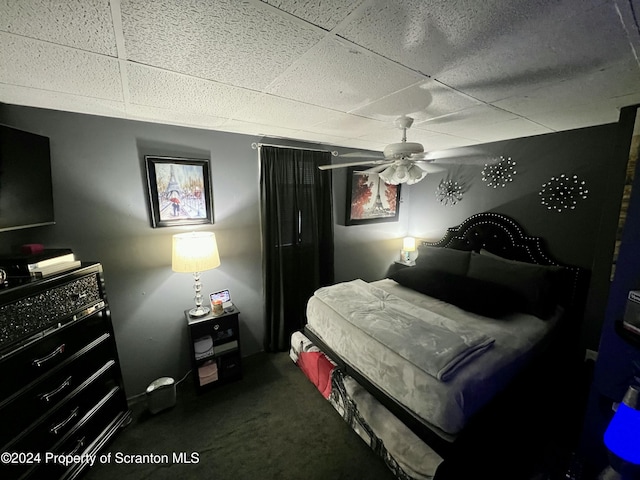 carpeted bedroom featuring a paneled ceiling and ceiling fan