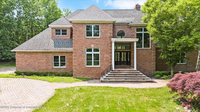 441 Hidden Lake Dr, East Stroudsburg, PA 18302 - colonial-style house with french doors, a shingled roof, a chimney, and a front lawn