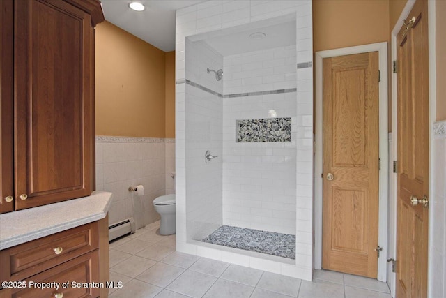 441 Hidden Lake Dr, East Stroudsburg, PA 18302 - bathroom featuring baseboard heating, a tile shower, tile walls, tile patterned floors, and a wainscoted wall