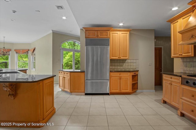 441 Hidden Lake Dr, East Stroudsburg, PA 18302 - kitchen with appliances with stainless steel finishes, decorative backsplash, dark stone counters, wall chimney range hood, and ornamental molding