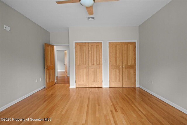441 Hidden Lake Dr, East Stroudsburg, PA 18302 - unfurnished bedroom with two closets, light wood-style flooring, and a ceiling fan