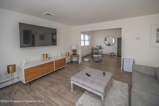 living room featuring hardwood / wood-style flooring and a baseboard heating unit