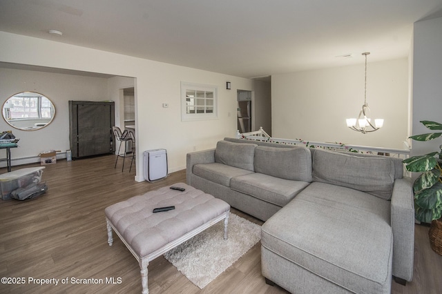 living room featuring an inviting chandelier, a baseboard radiator, and hardwood / wood-style floors