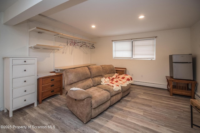 living room with a baseboard heating unit and wood-type flooring