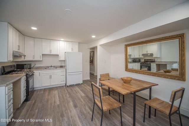 kitchen with gas range, sink, white cabinets, white refrigerator, and gas stove