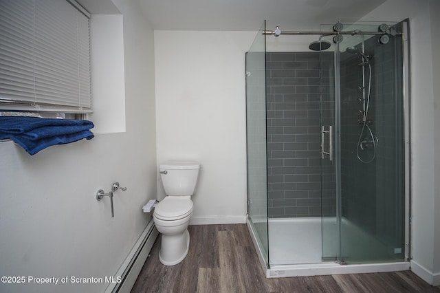 bathroom with baseboard heating, hardwood / wood-style flooring, toilet, and walk in shower