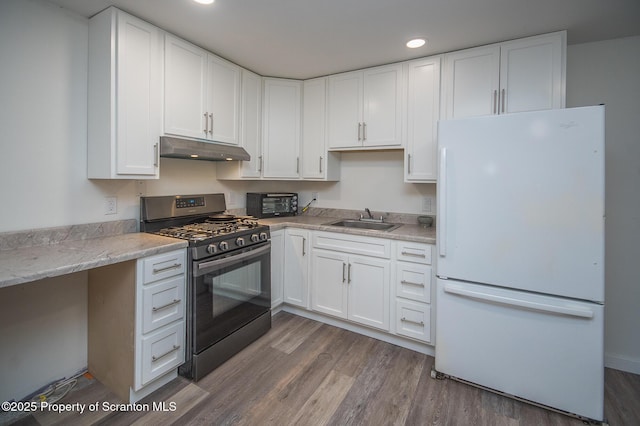 kitchen featuring sink, white cabinets, white fridge, dark wood-type flooring, and stainless steel range with gas stovetop