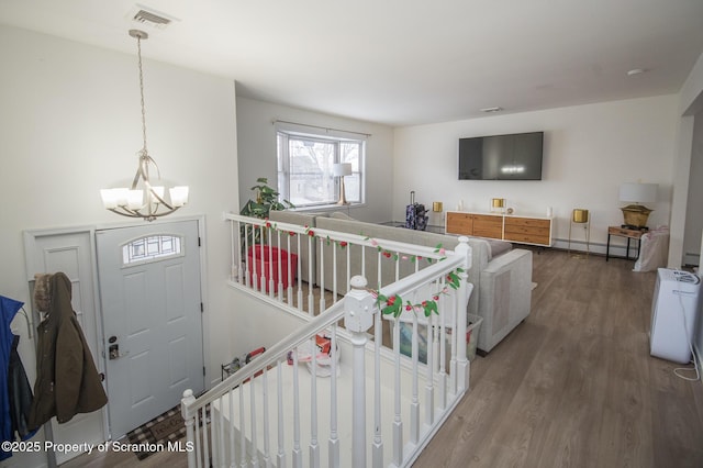 living room featuring an inviting chandelier, hardwood / wood-style floors, and baseboard heating