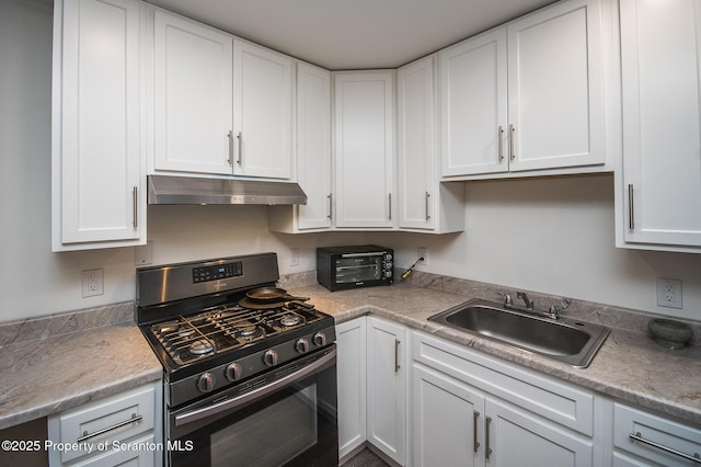 kitchen with stainless steel range with gas cooktop, sink, and white cabinets