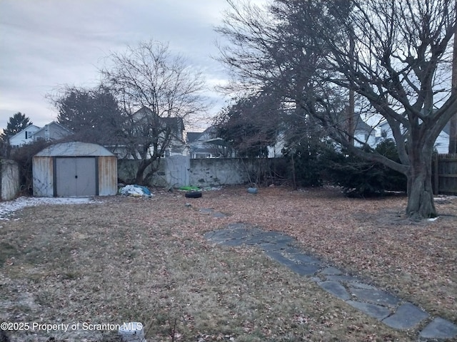 view of yard featuring fence, an outdoor structure, and a shed