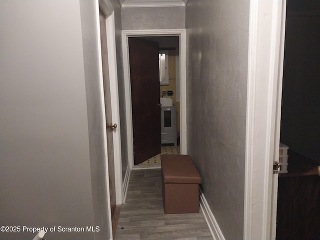 corridor featuring baseboards and wood finished floors