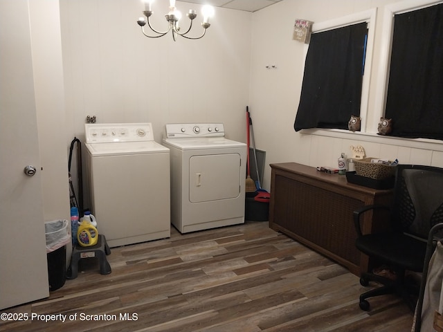 laundry room featuring washer and clothes dryer, a notable chandelier, laundry area, and wood finished floors