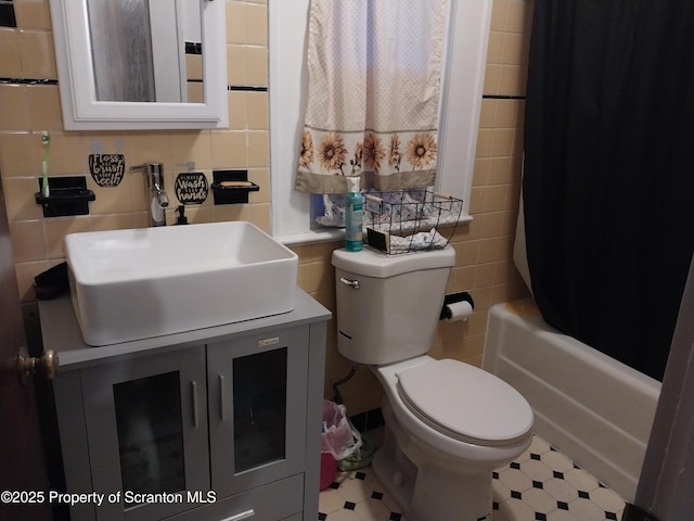 full bathroom with toilet, vanity, decorative backsplash, shower / tub combo, and tile walls