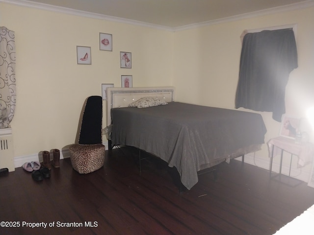 bedroom with wood finished floors, radiator, and ornamental molding