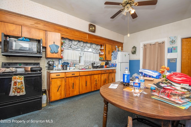 1010 Wood St, Old Forge, PA 18518 - kitchen featuring black appliances, ceiling fan, brown cabinets, light countertops, and wallpapered walls