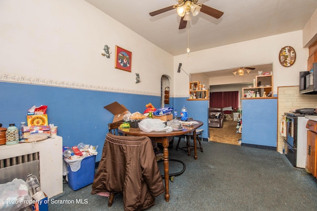 1010 Wood St, Old Forge, PA 18518 - dining area featuring ceiling fan, carpet flooring, a wainscoted wall, tile walls, and arched walkways