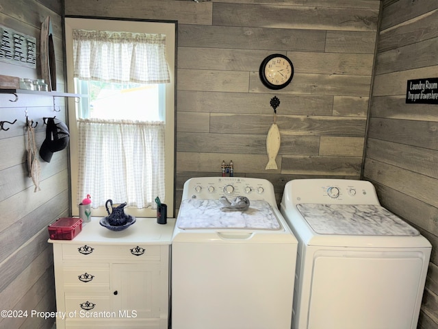 laundry room featuring washer and clothes dryer and wood walls