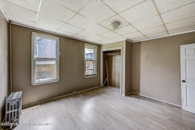 126-128 S Rebecca Ave S, Scranton, PA 18504 - unfurnished bedroom featuring wood finished floors, radiator heating unit, a drop ceiling, a closet, and baseboards
