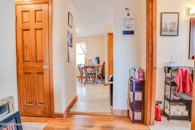 hallway with baseboards and light wood-style flooring