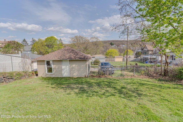 view of yard with fence and an outbuilding