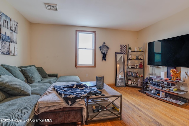 living area featuring wood finished floors and visible vents