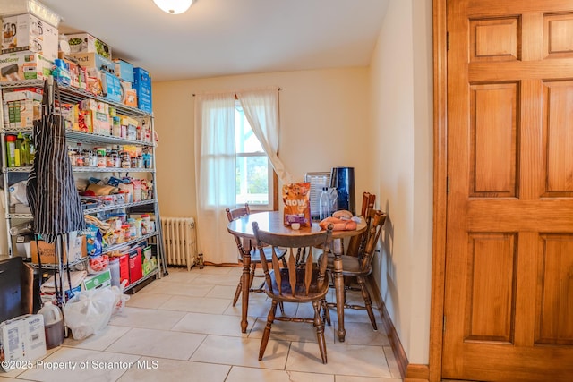 dining space featuring radiator and light tile patterned floors
