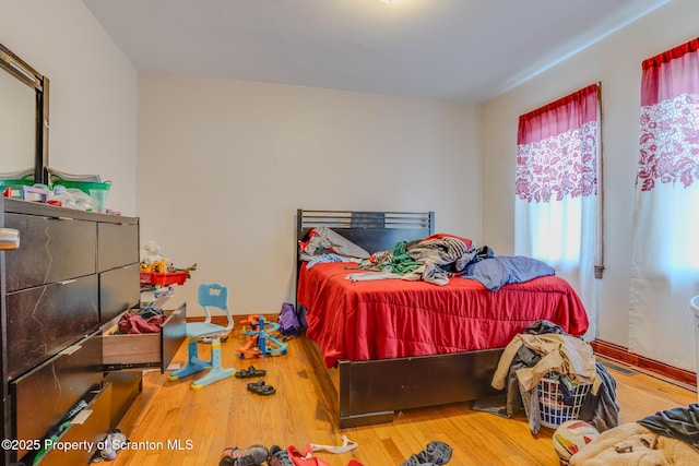 bedroom with baseboards and hardwood / wood-style floors