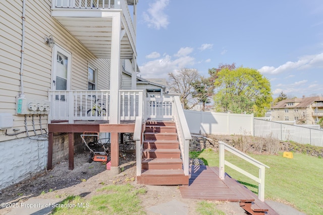 exterior space featuring a deck, fence, and stairs