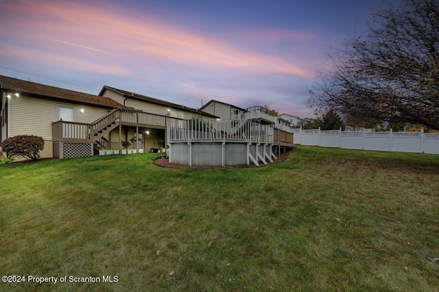 yard at dusk featuring a swimming pool side deck