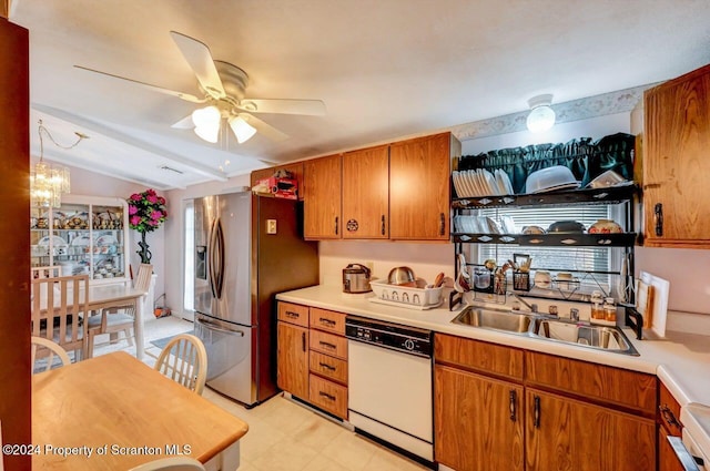 kitchen with lofted ceiling, white dishwasher, ceiling fan with notable chandelier, sink, and stainless steel fridge