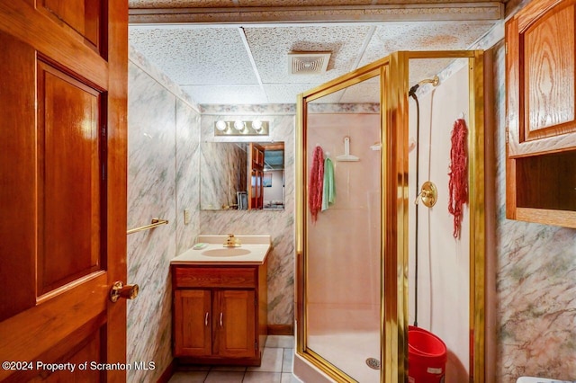 bathroom featuring tile patterned floors, a paneled ceiling, vanity, and a shower with shower door