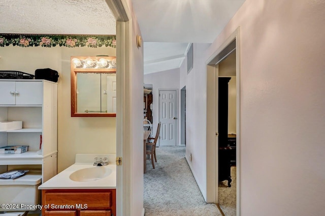 bathroom with toilet, vanity, and vaulted ceiling