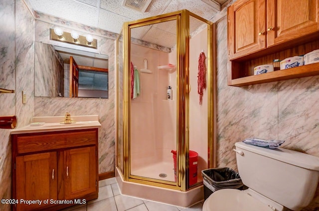 bathroom with tile patterned floors, vanity, a shower with shower door, and toilet