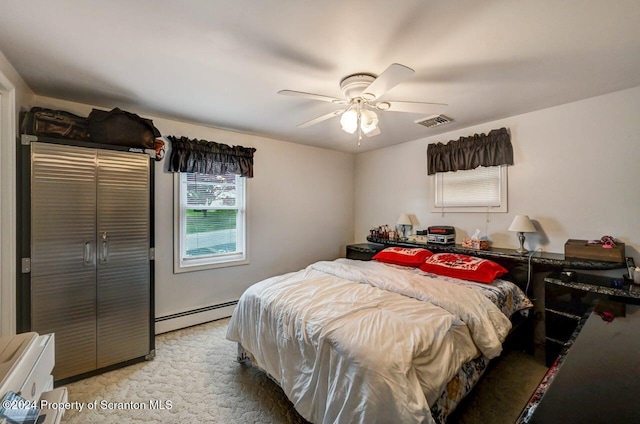 carpeted bedroom with ceiling fan and baseboard heating