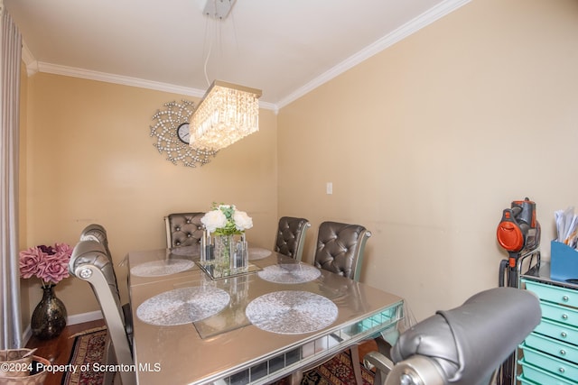 dining room with hardwood / wood-style floors, a notable chandelier, and ornamental molding