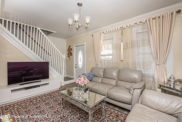 living room with a notable chandelier, wood-type flooring, and ornamental molding