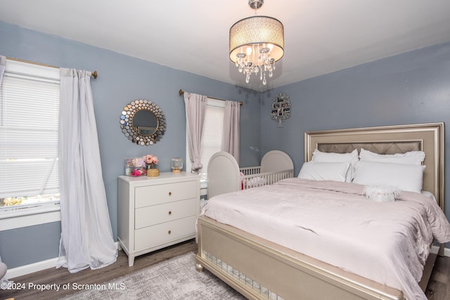 bedroom with light hardwood / wood-style floors and an inviting chandelier