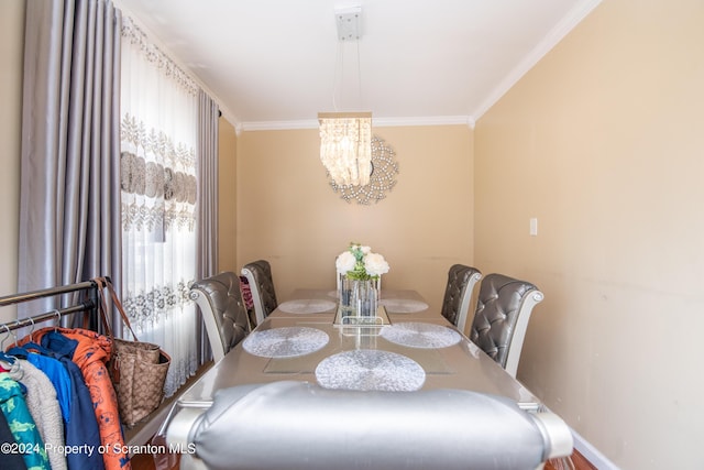 dining space with crown molding and a chandelier