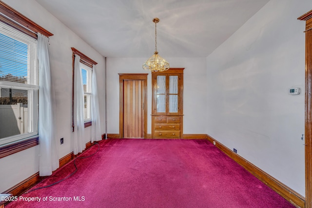 unfurnished room featuring carpet flooring and a chandelier