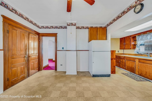 kitchen with white refrigerator, ornamental molding, and ceiling fan