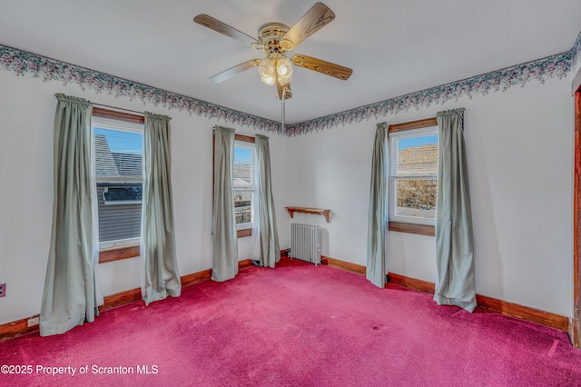 unfurnished room featuring a healthy amount of sunlight, carpet, radiator, and ceiling fan